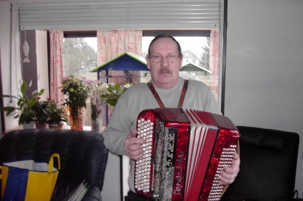 Guy Dejaifve jouant de son accordéon rouge